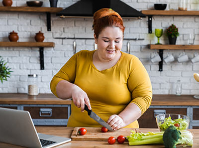 manage your weight, woman cutting vegetables in the kitchen